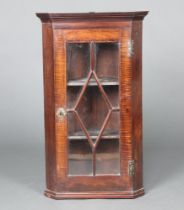 A 19th Century mahogany hanging corner cabinet with moulded cornice, fitted shelves enclosed by an