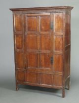 An oak cabinet constructed of 18th Century panelled timber with moulded and dentil cornice