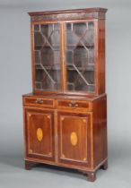 An Edwardian inlaid mahogany display cabinet on cabinet with moulded cornice and blind fret work