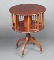 An Edwardian circular mahogany revolving bookcase, raised on a turned column and tripod base with