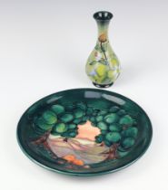 A modern Moorcroft green ground plate with landscape view 26cm, a ditto oviform vase decorated