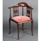 An Edwardian mahogany corner chair with upholstered seat, raised on cabriole supports with X