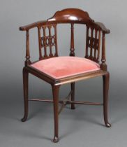 An Edwardian mahogany corner chair with upholstered seat, raised on cabriole supports with X