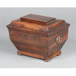 A Georgian rosewood twin compartment tea caddy of sarcophagus form with hinged lid and ring drop