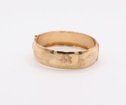 A 9ct yellow gold engraved bangle 24.4 grams