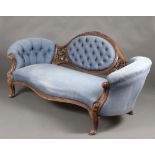 A Victorian carved mahogany show frame sofa upholstered in blue buttoned material, raised on