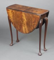 A 1920's Queen Anne style oval walnut veneered drop flap tea table raised on cabriole supports
