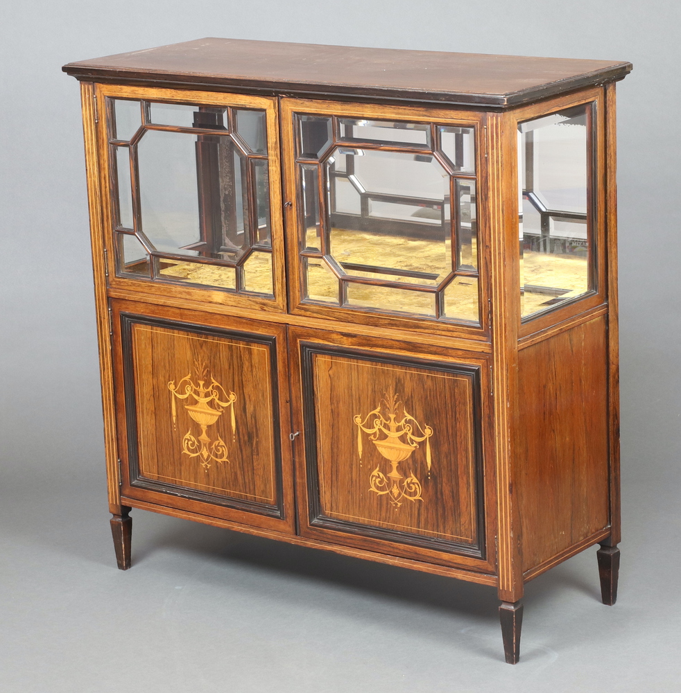 An Edwardian inlaid mahogany display cabinet with mirrored back and plush interior, enclosed by