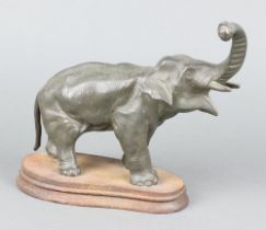 A spelter figure in the form of a standing elephant, possibly the base of a mystery clock, raised on