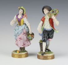 A pair of 20th Century German figures of a lady and gentleman carrying flowers on raised circular