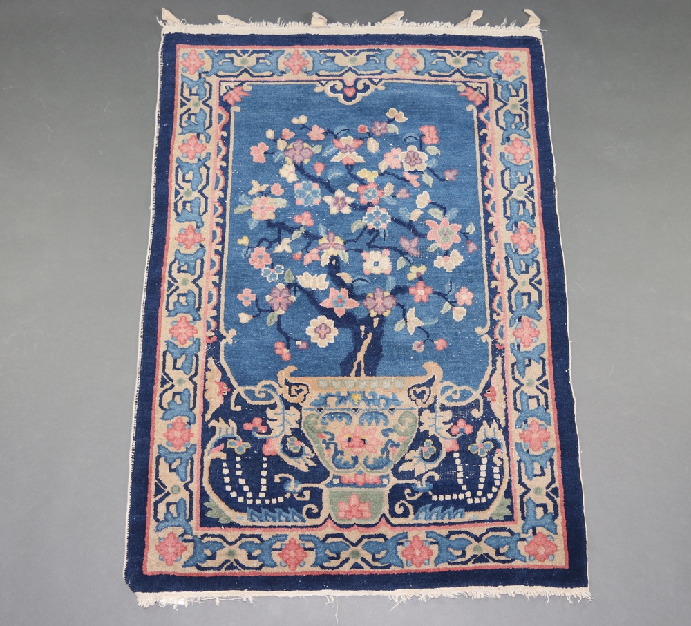 A 1930's blue ground and floral patterned Chinese rug depicting an urn of flowers 137cm x