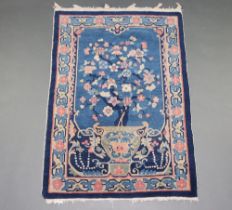 A 1930's blue ground and floral patterned Chinese rug depicting an urn of flowers 137cm x