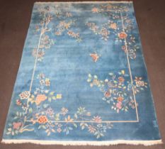 A 1930's blue and floral ground Chinese carpet decorated a butterfly 366cm x 274cm Some light