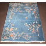 A 1930's blue and floral ground Chinese carpet decorated a butterfly 366cm x 274cm Some light