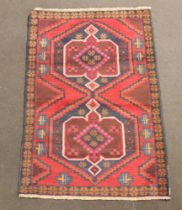 A blue, red and black ground Belouche rug with 2 medallions to the centre 136cm x 89cm