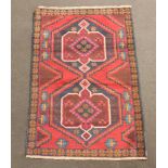 A blue, red and black ground Belouche rug with 2 medallions to the centre 136cm x 89cm