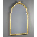 A 1950's Georgian style arch shaped bevelled plate mirror contained in a gilt frame surmounted by