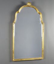 A 1950's Georgian style arch shaped bevelled plate mirror contained in a gilt frame surmounted by