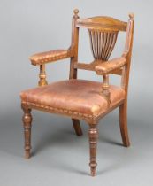 An Edwardian light oak bar back open arm chair with vase shaped slat back, seat and back uphold in