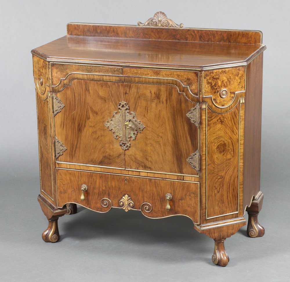 A 1930's Italian style walnut side cabinet/wash stand with raised back carved a shell, fitted a