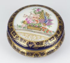 A modern Continental circular blue ground box and cover the lid with a mask and basket of flowers