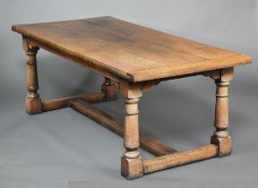 A 17th Century style oak refectory dining table, the top formed of 3 planks raised on turned and