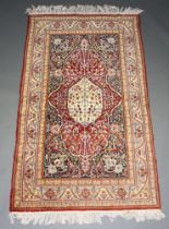 A brown, blue and green ground Persian rug with central medallion within a multi row border 213cm