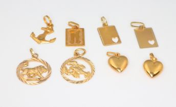 Eight yellow metal 18k charms, 5.5 grams
