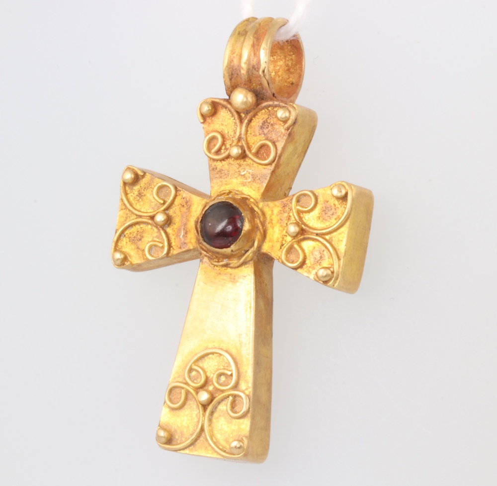 A Roman style yellow metal cabochon garnet set cross pendant with Etruscan style decoration 4.7