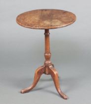 An 18th Century circular oak wine table raised on a turned column and tried base 68cm h x 51cm diam.