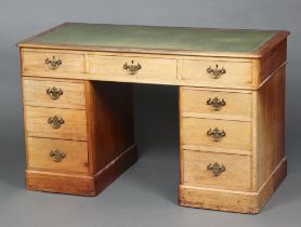 A Victorian mahogany kneehole pedestal desk with green inset writing surface above 1 long and 8
