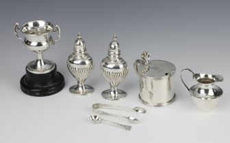 A Georgian style silver mustard pot Sheffield 1923, a trophy cup, 2 condiments, jug, sugar nips