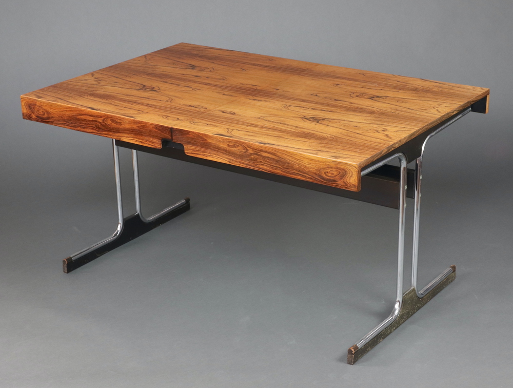 A 1970's Pieff style rosewood extending dining table, raised on figured chrome supports with