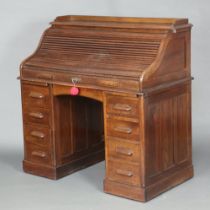 An Edwardian oak roll top desk, the top with 3/4 gallery and well fitted interior, the base fitted 1