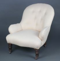 A Victorian metal framed armchair upholstered in white buttoned material raised on turned