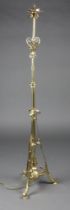 A Victorian brass adjustable oil lamp stand converted to a standard lamp with wrought decoration,