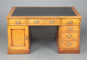 A Victorian light oak kneehole partners desk with inset writing surface above 1 long and 8 short