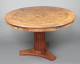 A Georgian style figured walnut and crossbanded pedestal dining table raised on a turned and