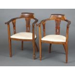 A pair of Edwardian beech framed tub back chairs with splat back decoration, the seats of serpentine