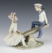 A Lladro group of a boy and girl on a see saw 22cm