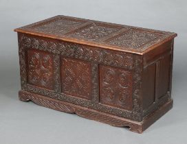 An 18th Century carved oak coffer of panelled construction with later Victorian carved oak panels