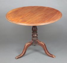 A 19th Century circular bleached mahogany snap top tea table raised on baluster turned column and