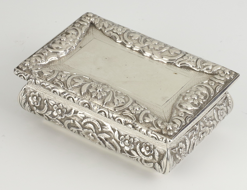 A Victorian rectangular silver table top snuff box decorated with flowers and vacant cartouche