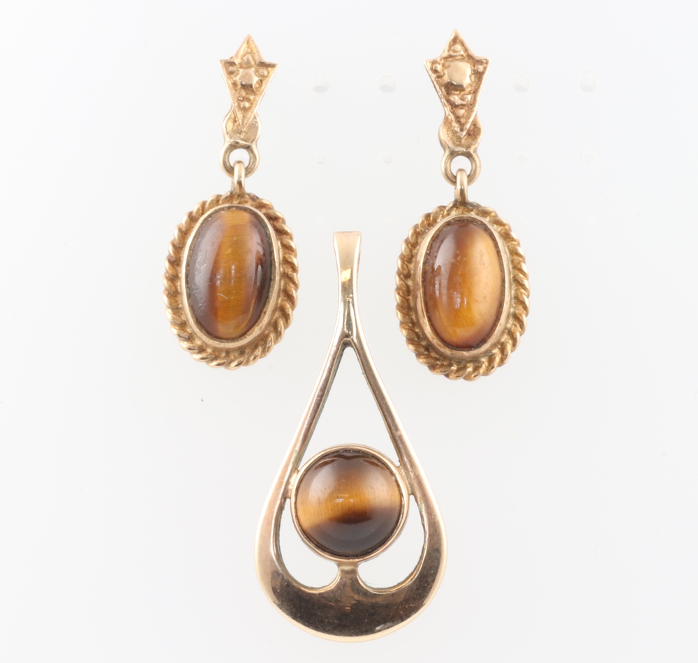 A 9ct yellow gold Tigers Eye pendant 30mm and a pair of ditto ear studs, gross weight 7 grams