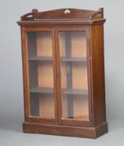 An Art Nouveau, Liberty style mahogany display cabinet with 3/4 gallery, the interior fitted shelves