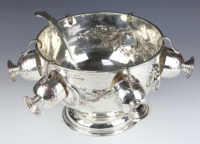 A Georgian style repousse silver plated pedestal punch bowl with 6 cups and ladle