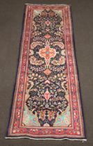 A blue and red floral ground Persian runner 321cm x 107cm