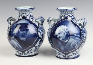 A pair of 19th/20th Century Delft twin handled vases decorated fisherfolk, the base marked Delft B.
