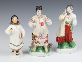 Three 20th Century Russian porcelain figures of standing ladies and a gentleman 24cm All three