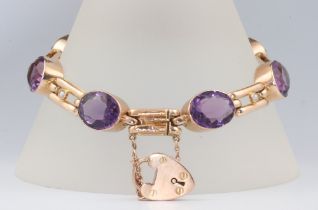 A 9ct yellow gold bracelet set with 7 oval cut amethysts each 12mm x 9mm and 6 seed pearls, having a